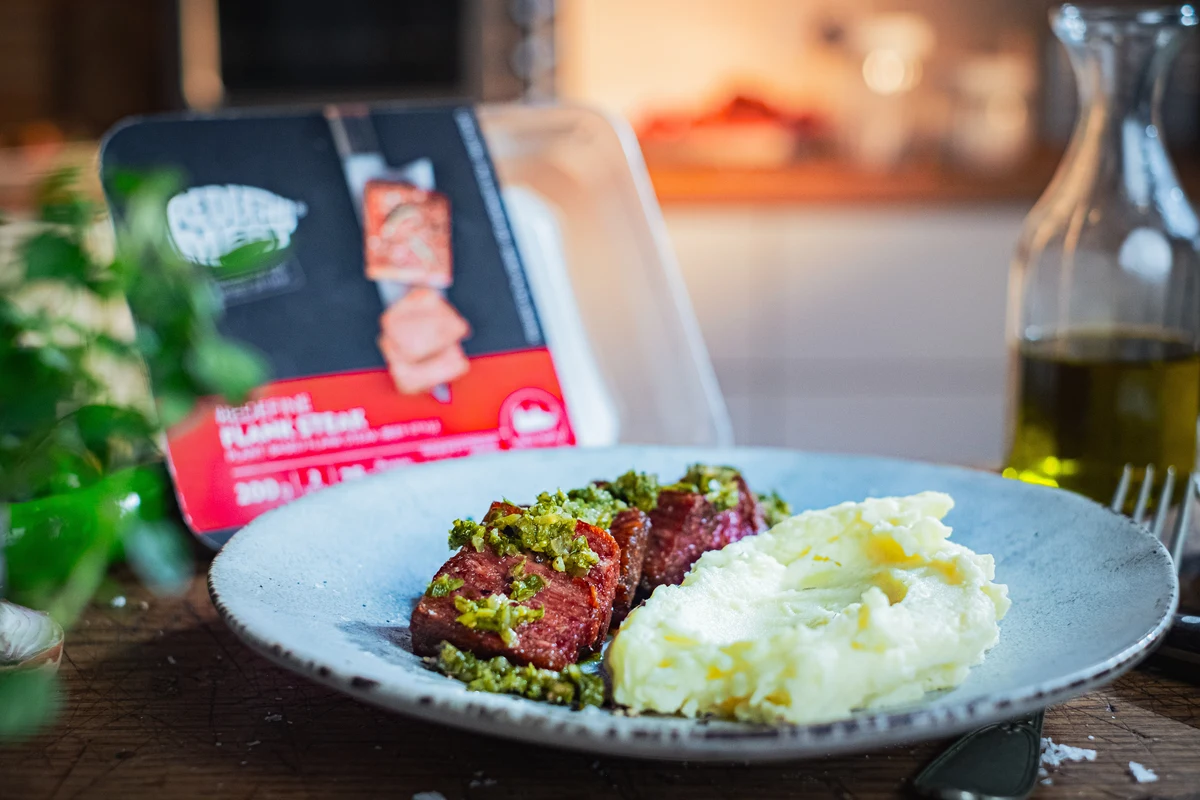 Redefine Flank Steak with chimichurri and mash, the pack behind it