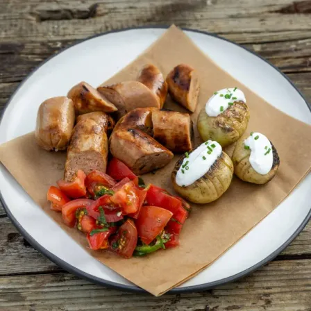 Gegrillte Redefine Bratwurst mit Bratkartoffeln und Tomatensalat