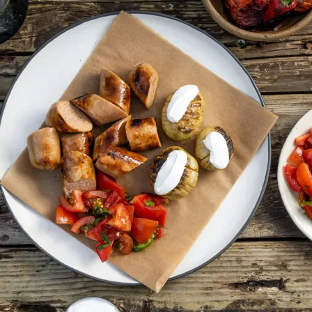 Redefine Bratwurst van de BBQ met gebakken aardappelen en tomatensalade