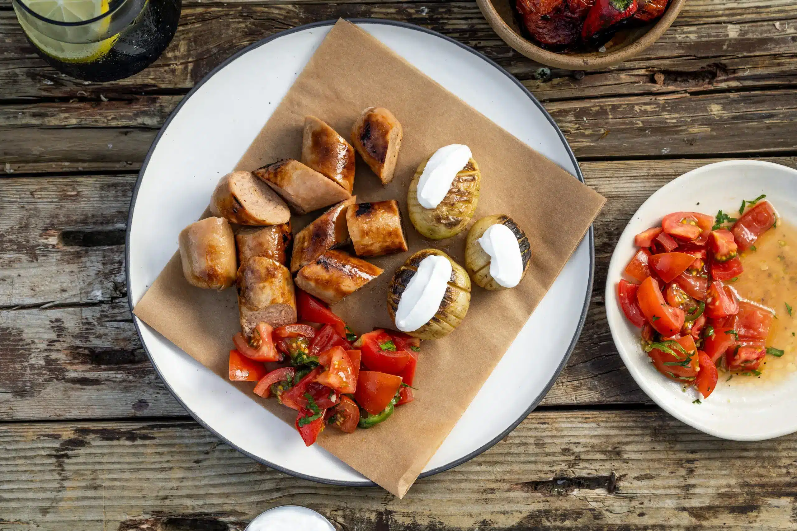 Redefine Bratwurst van de BBQ met gebakken aardappelen en tomatensalade